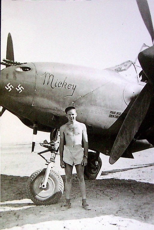 James P. Dibble standing by his P-38 named Mickey after his wife